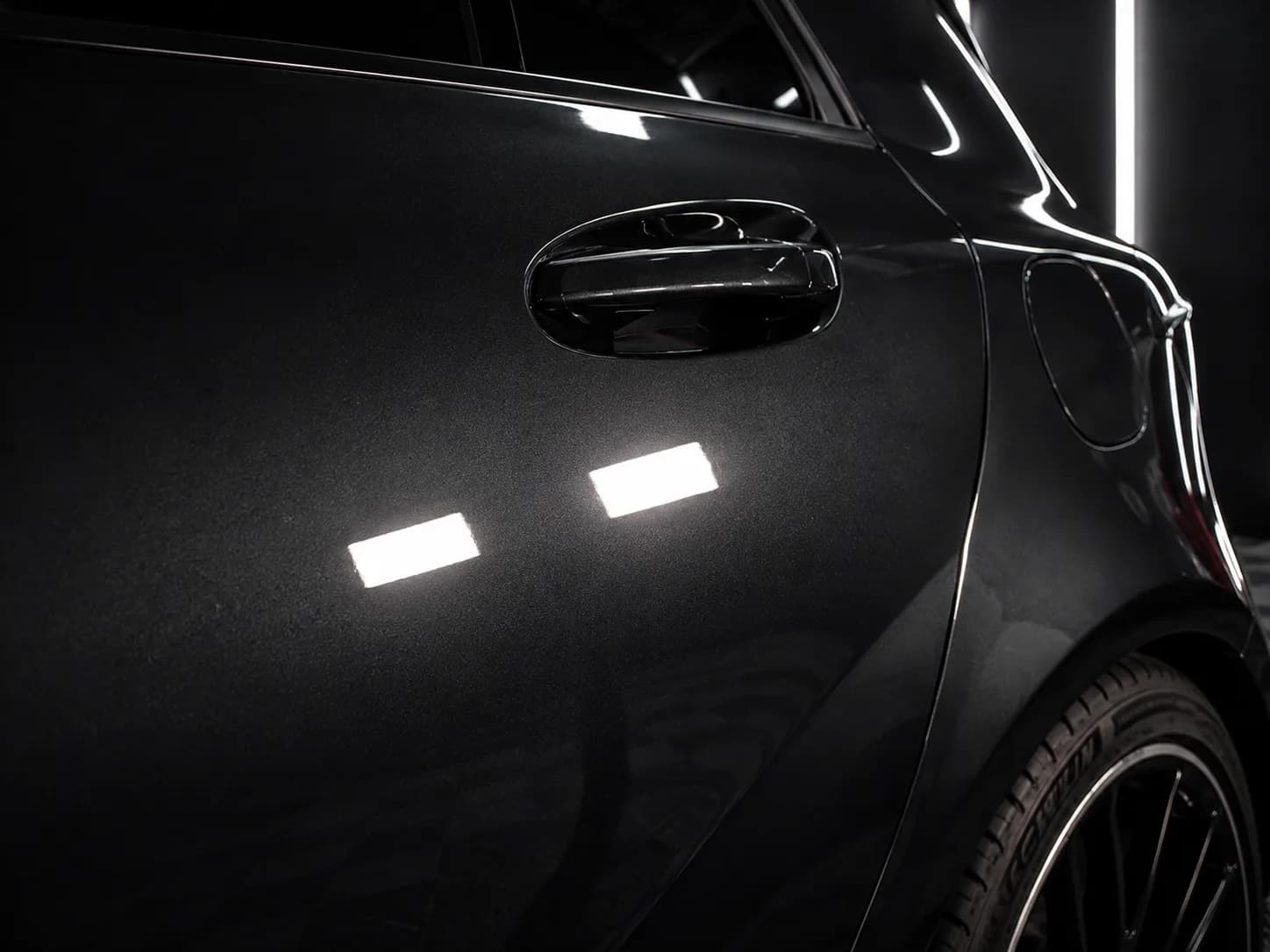 Dark vehicle paint detail under studio lights — paint protection ready